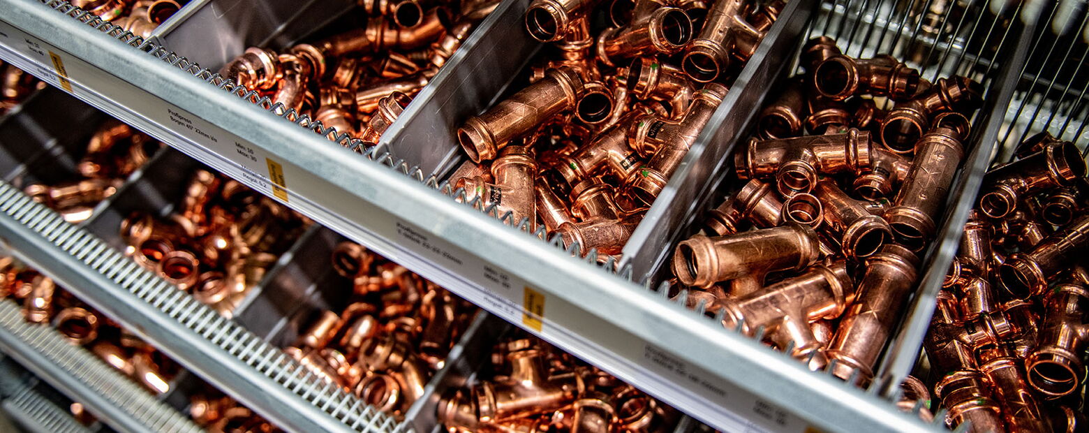 Lagerregal mit sortierten Kupferrohr-Fittings und Rohrverbindern in verschiedenen Größen und Formen